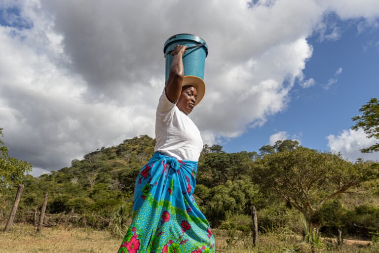 Fungai Mugwenyi carrying a bucket of water at Musenyereki Primary School