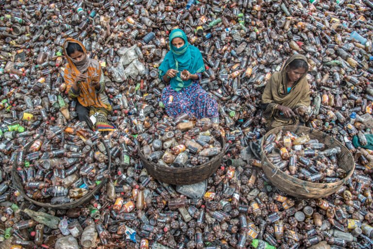 Female workers sort through a pile of tens of thousands of plastic household items for them to be recycled in a recycling plastic factory in Barishal, Bangladesh.
