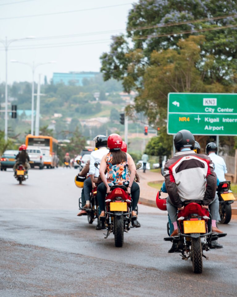 A group of people riding on electric motorcycles in Kigali, Rwanda.