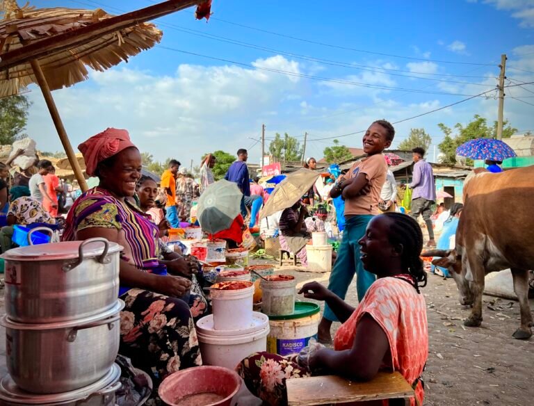 Vendors laugh in the midday heat in a traditional market