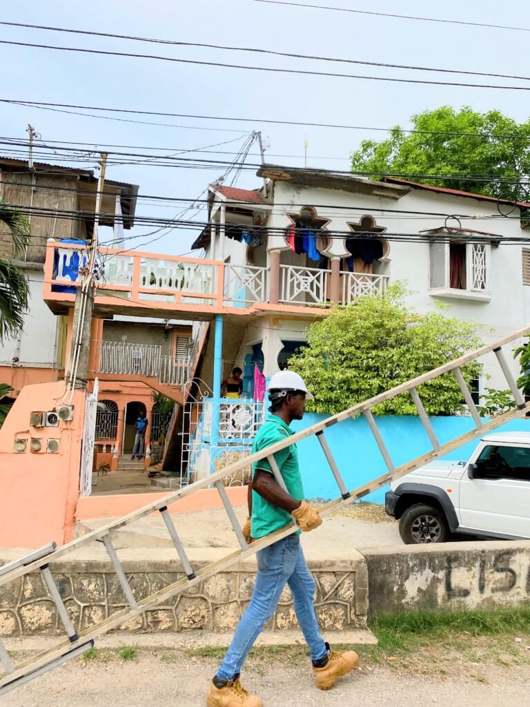 A man holding a ladder in Steer Town, Jamaica
