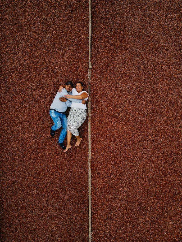 Two Colombian cocoa farmers lying on 800 kilos of cocoa beans.