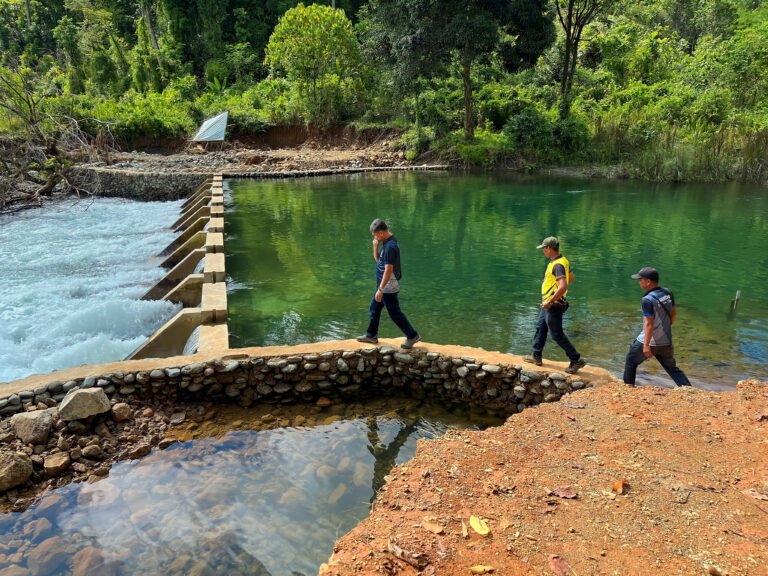 Water workers showing USAID program staff a newly built climate-resilient water intake structure