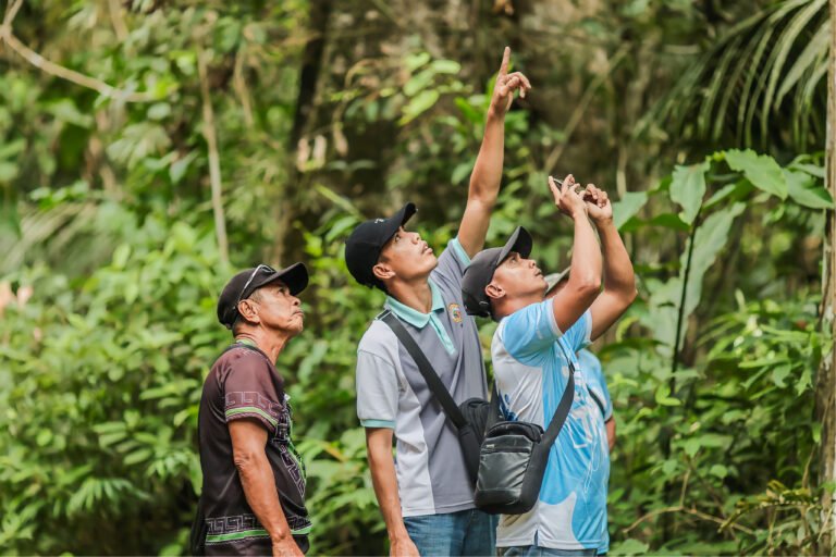 Three forest patrollers take a snapshot using a mobile phone for the Lawin forest and biodiversity protection system