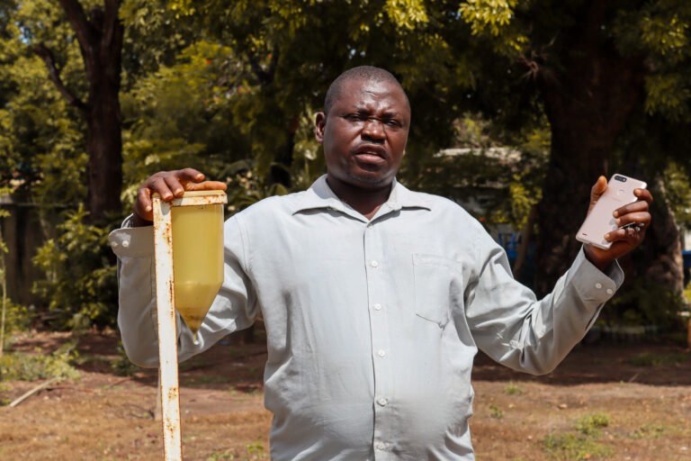 Feed the future Senegal Dooleel Mbay_ Kansera Sambou- field extension agent explaining how they use the manual rain gauges and share information with the smartphone