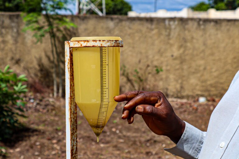 Feed the future Senegal Dooleel Mbay_ Kansera Sambou- field extension agent explaining how they use the manual rain gauges and share information with the smartphone