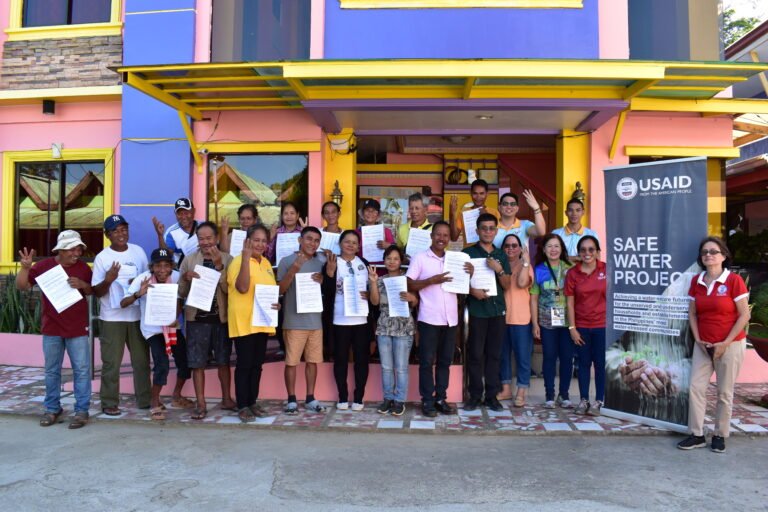 Group of people holding up papers for camera