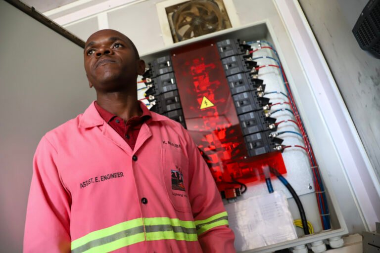 Utility engineer Kule Mulibathi stands in the power control room at the Kasenyi solar-powered hybrid mini-grid station in Kasese District, western Uganda