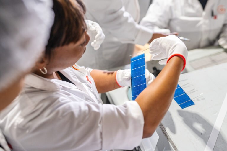 A woman holding a string for a solar panel while others look on.