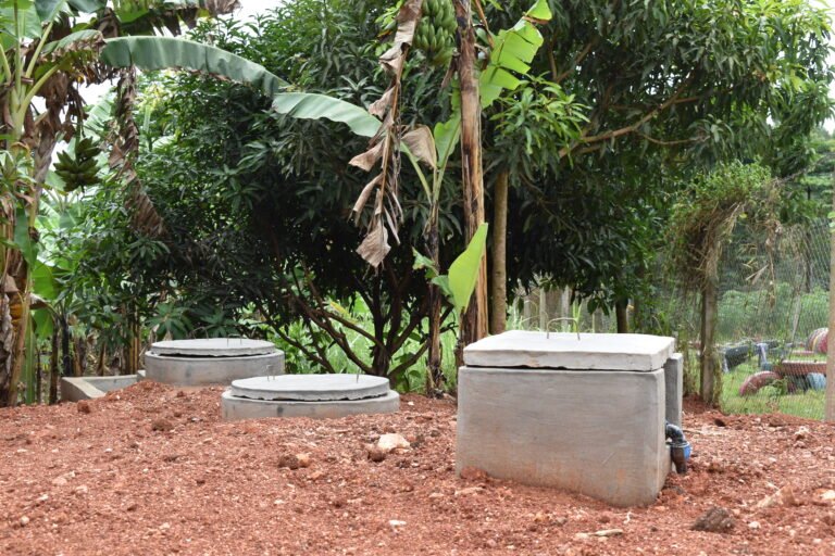 A cement biogas system near a wooded area.