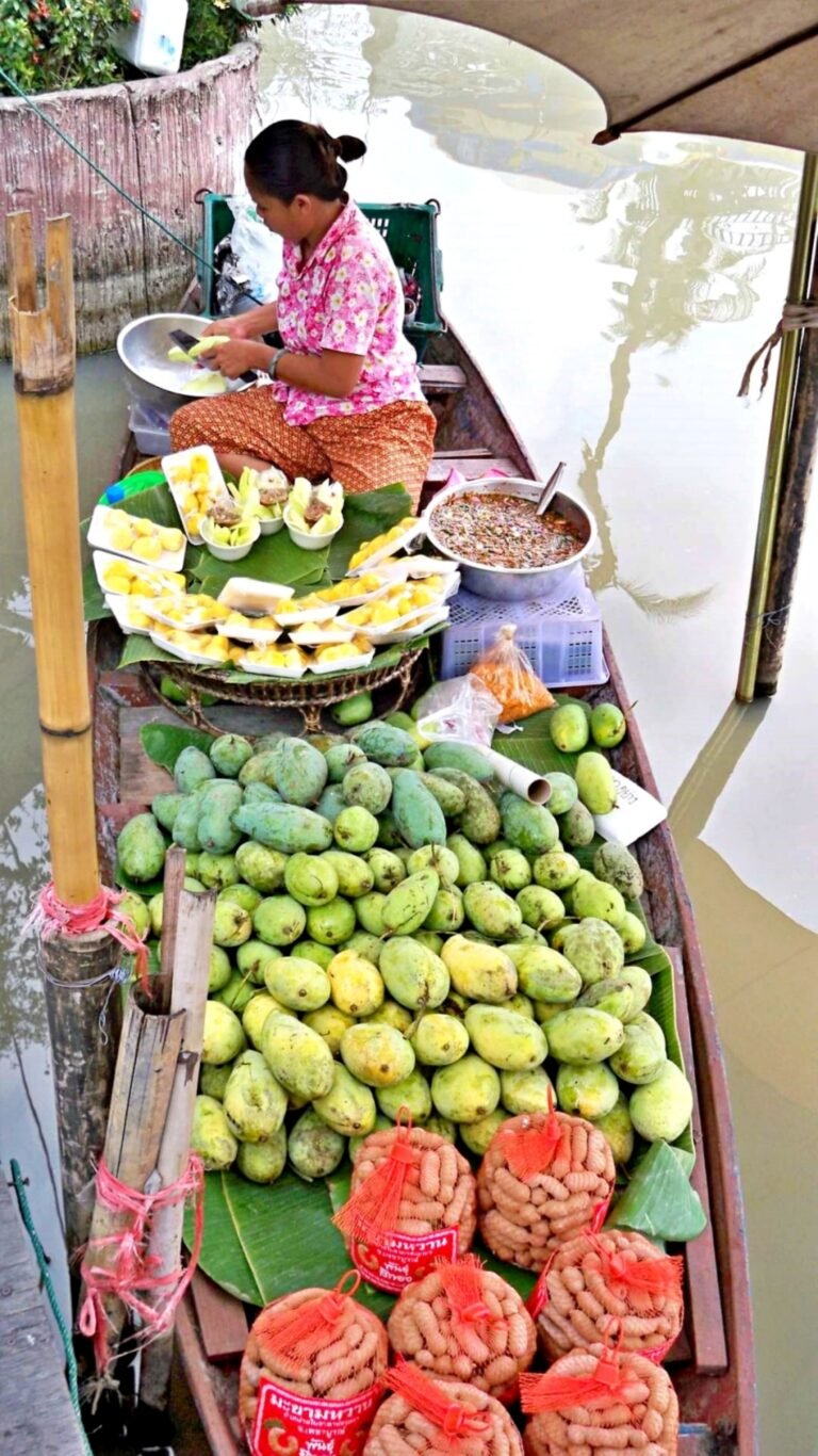 Woman sitting on a boat with produce she is selling.