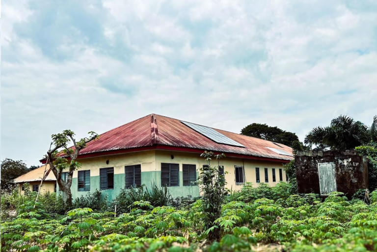 Healthcare facility surrounded by vegetation, with a solar panel on its roof