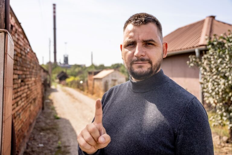 A man holds up a dirty finger to the camera.