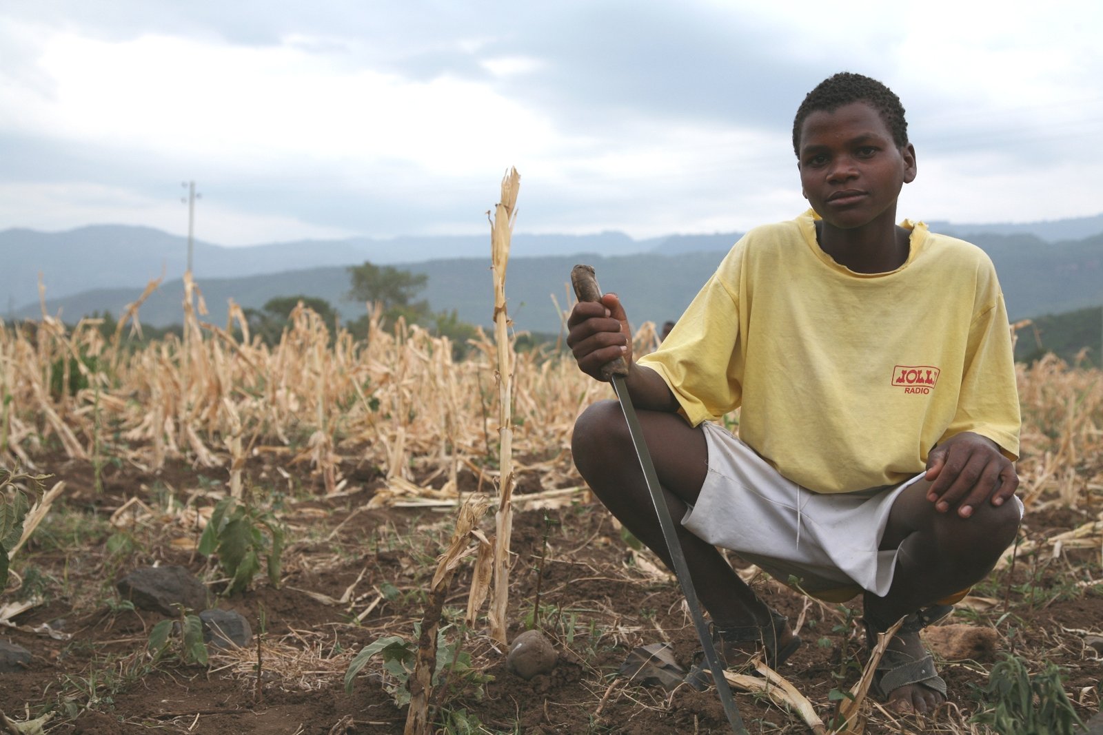A young boy sitting in a drought land