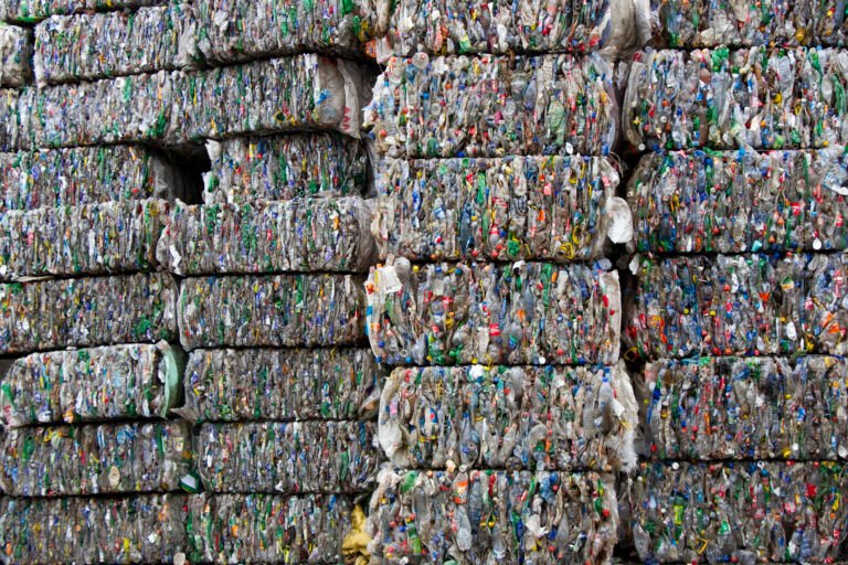 Stacks of compressed recyclable materials fill the frame.
