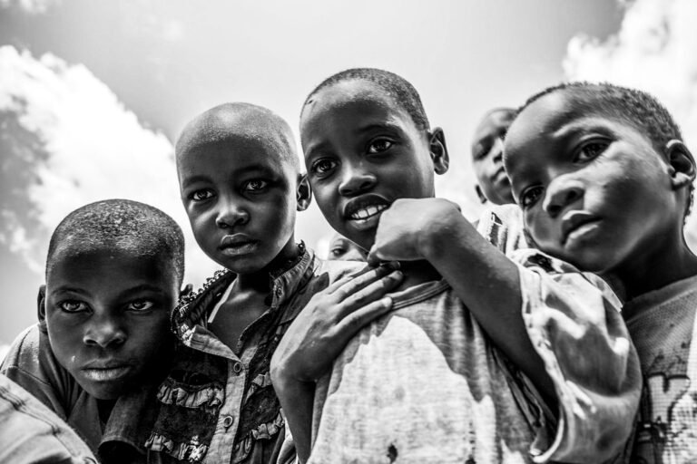 Children looking at a the camera with sky behind them.