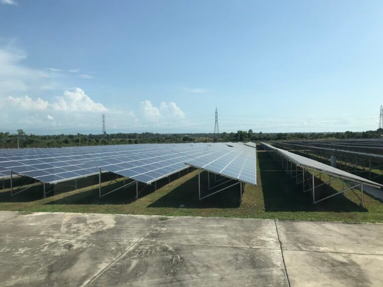 A solar PV field with a blue sky above it.