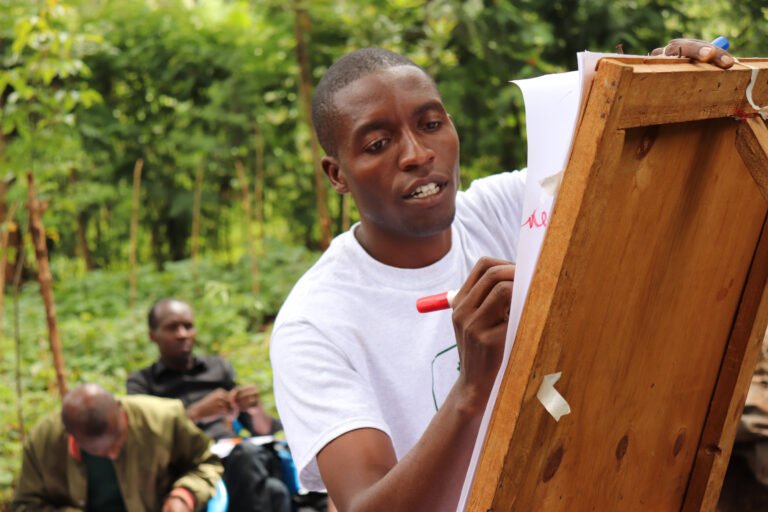 A man draws on an easel in an outdoor setting.